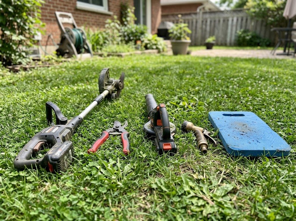 A row of outdoor tools leaning against a wooden shed